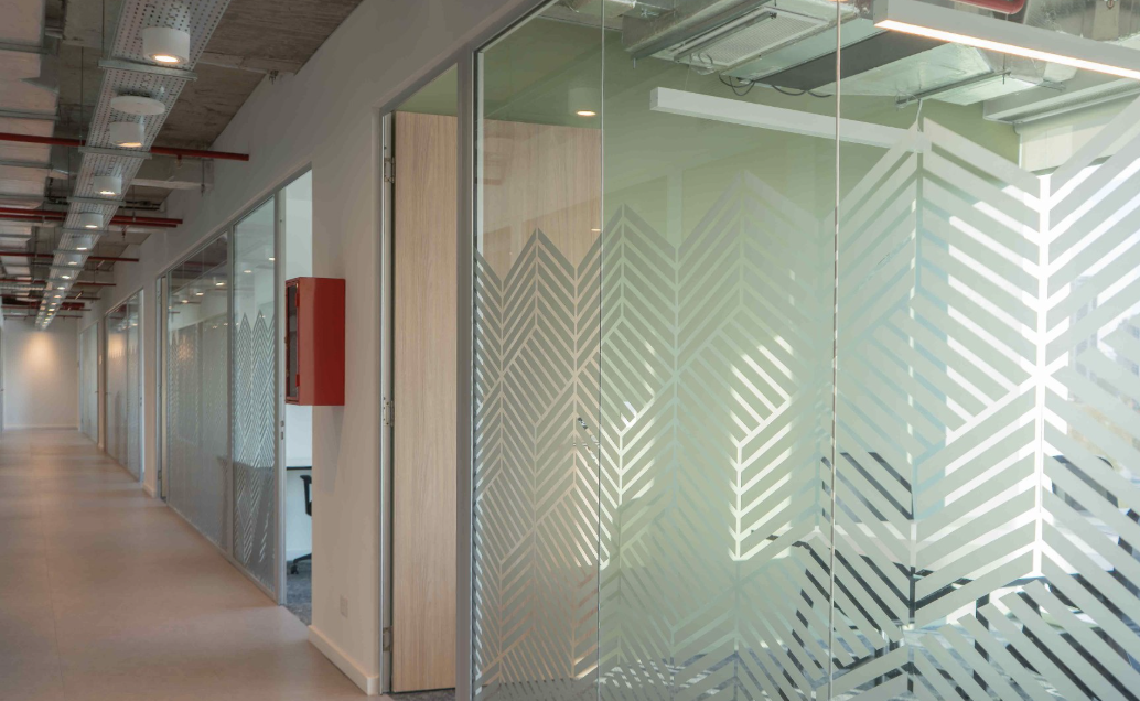 Pasillo con salas de reunión vidriadas en las oficinas de Andina Sur